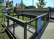 Thumbnail 51 of 102 - A tennis court with a blue sign on the fence.