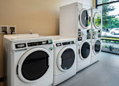 Thumbnail 87 of 102 - A row of white front load washing machines in a store.
