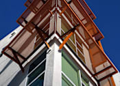 Thumbnail 92 of 94 - A building with a white facade and a brown roof.
