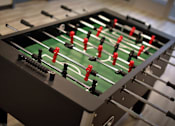 Thumbnail 90 of 94 - A foosball table with red and black players.