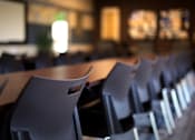 Thumbnail 76 of 94 - A classroom with rows of chairs and a projector screen.