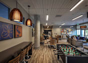 Thumbnail 68 of 94 - A room with a foosball table and a bar area.
