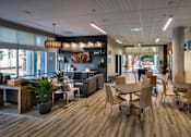 Thumbnail 64 of 94 - A modern office space with wooden floors and a variety of seating options.