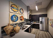Thumbnail 58 of 94 - A kitchen with a refrigerator, sink, and decorative wall art.