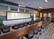 Thumbnail 54 of 94 - A conference room with a long table and chairs.