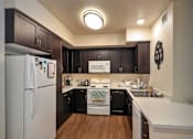 Thumbnail 42 of 94 - A kitchen with a white refrigerator and wooden floors.