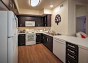Thumbnail 38 of 94 - A kitchen with a white refrigerator and black cabinets.