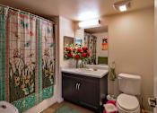 Thumbnail 35 of 94 - A bathroom with a shower curtain and a toilet.