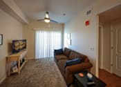 Thumbnail 28 of 94 - A living room with a brown couch and a ceiling fan.