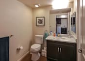 Thumbnail 27 of 94 - A bathroom with a toilet, sink, and mirror.