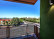 Thumbnail 18 of 94 - A balcony with a view of a road and trees.
