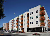 Thumbnail 21 of 94 - A modern apartment building with white and orange balconies.