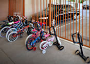 Thumbnail 16 of 94 - A row of bikes and scooters are lined up against a fence.