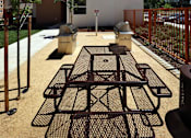 Thumbnail 15 of 94 - A modern building with orange balconies and a black metal table in front.
