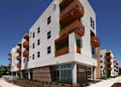 Thumbnail 20 of 94 - A modern building with a white facade and balconies on the upper floors.