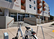 Thumbnail 23 of 94 - A bicycle is parked on a concrete surface in front of a building.