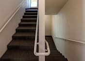 Thumbnail 9 of 94 - A staircase with a white railing and brown carpeting.