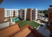 Thumbnail 12 of 94 - A view of a courtyard from a balcony with a pool.