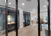 Thumbnail 18 of 38 - A modern interior with a glass door and a wooden floor.
