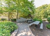Thumbnail 38 of 44 - a picnic table and benches in a park with trees  at Cumberland Crossing, Cumberland, Rhode Island