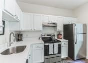 Thumbnail 1 of 44 - a white kitchen with stainless steel appliances and white cabinets  at Cumberland Crossing, Rhode Island, 02864