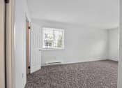 Thumbnail 23 of 52 - A room with a carpeted floor and a window with blinds.