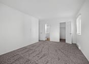 Thumbnail 27 of 52 - A carpeted room with a doorway leading to another room.