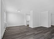 Thumbnail 37 of 52 - A room with wooden flooring and white walls.