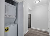 Thumbnail 51 of 52 - A small white fridge with a yellow sticker on it is in a room with a black fridge in the background.