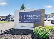 Thumbnail 22 of 52 - A sign for Ridgeway Place Apartments stands in front of a row of houses.