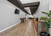 Thumbnail 26 of 52 - A long hallway with wood floors and a bench.