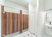 Thumbnail 38 of 38 - A bathroom with a white sink and a wooden partition.