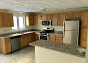 Thumbnail 16 of 21 - Birchwood Hills Townhomes Kitchen with oak cabinets, light colored floor, granite countertops and stainless steel appliances.