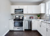 Thumbnail 5 of 14 - a kitchen with stainless steel appliances and white cabinets at Pleasant View Estates, Griswold, Connecticut