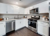 Thumbnail 4 of 14 - a kitchen with stainless steel appliances and white cabinets at Pleasant View Estates, Griswold, 06351