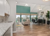 Thumbnail 7 of 57 - A kitchen with a granite countertop and a dining area with a table and chairs. at South Winds Apartments, Fall River
