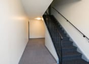 Thumbnail 43 of 57 - A staircase with a black railing and a grey carpet. at South Winds Apartments, Fall River, 02720