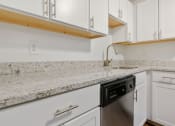 Thumbnail 27 of 57 - A kitchen with white cabinets and a granite countertop. at South Winds Apartments, Fall River, 02720