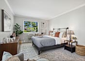 Thumbnail 13 of 20 - A bedroom with a large bed and a window overlooking a backyard.