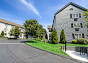 Thumbnail 4 of 20 - A sunny day at a residential area with two buildings and a tree.