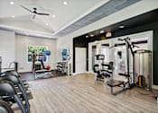Thumbnail 10 of 20 - A gym with a variety of equipment including weights and cardio machines.