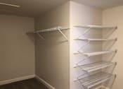 Thumbnail 22 of 27 - a walk in closet with empty shelves on the wall