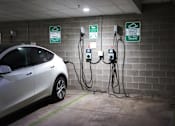Thumbnail 27 of 32 - a car plugged into a charging station in a parking garage