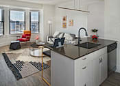 Thumbnail 8 of 10 - A modern kitchen with a black countertop and white cabinets.