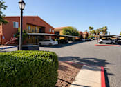 Thumbnail 7 of 23 - A street view of a building with a red hedge in the foreground.