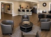 Thumbnail 17 of 23 - A living room with a grey sofa and a black coffee table.