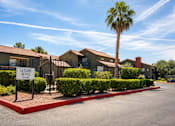Thumbnail 11 of 23 - A leasing office sign is in front of a building with a palm tree.