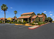 Thumbnail 2 of 23 - A building with a red roof and palm trees in front.
