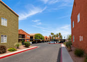 Thumbnail 15 of 23 - A parking lot is surrounded by two buildings.