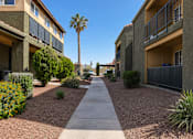 Thumbnail 16 of 23 - A pathway leads through a landscaped courtyard between two apartment buildings.
